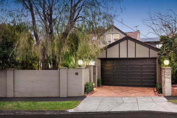 the front of a house with brick retaining walls.